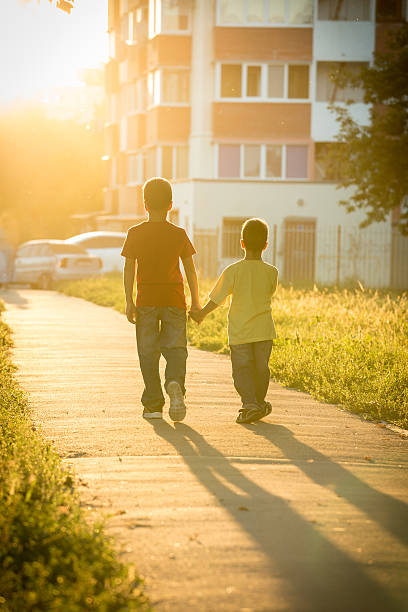 istock Two boys running together on street 612631024