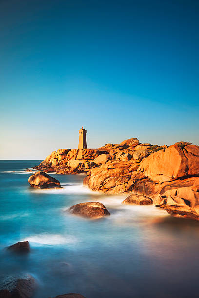 istock Ploumanach lighthouse sunset in pink granite coast, Brittany, Fr 612635398