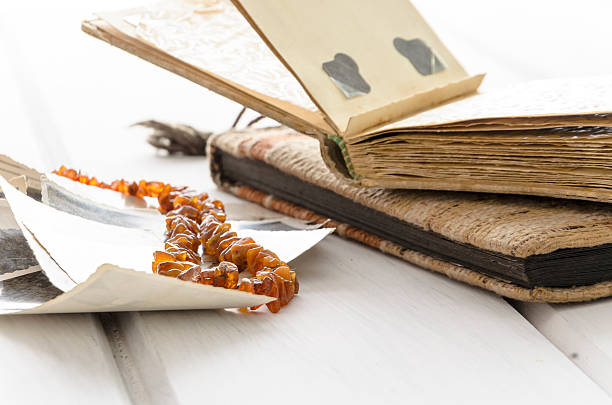 istock Stack of old photographs with amber necklace 612636044