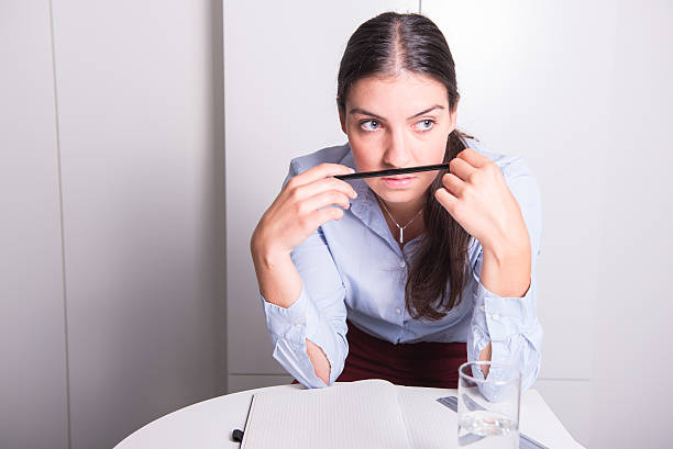 istock young woman with pencil under her nose is thinking 612637328