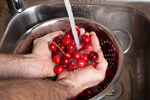 istock male hands wash cherries under running water 612637360