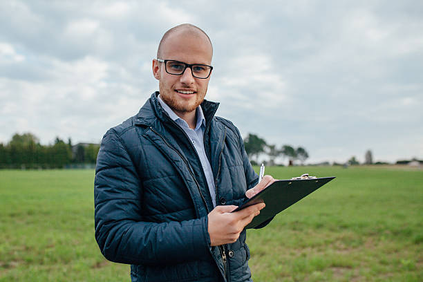 Young investor is signing a documents while looking up stock photo