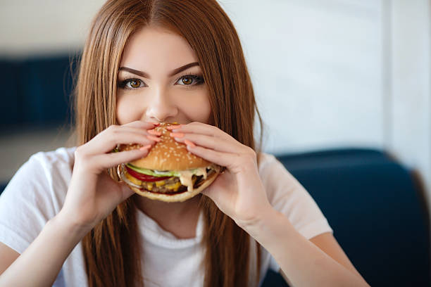 istock Lady with a hamburger for a table in a cafe 612641422