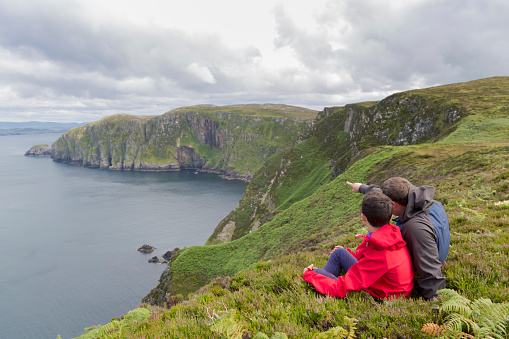 Father and son admires beauty landscape. Location Horn Head in Ireland co. Donegal