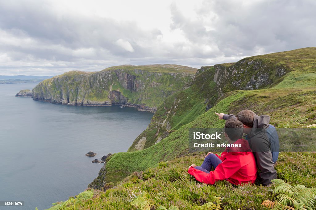 Father and son admires beauty landscape. Father and son admires beauty landscape. Location Horn Head in Ireland co. Donegal Vacations Stock Photo