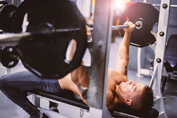 Strive for progress, not perfection Portrait image of young athlete in gym, during body building training for muscle definition. Series of  images of young athlete during training in professional gym, lifting weights for biceps, pectorals and back muscles. Location: Novi Sad, Serbia, Europe pectoral muscle stock pictures, royalty-free photos & images