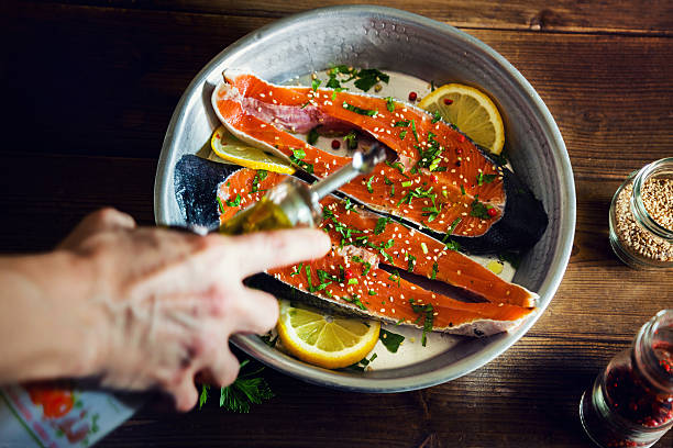 rodajas de salmón sazonadas con limón, aceite de sésamo y perejil - baked salmon fotografías e imágenes de stock