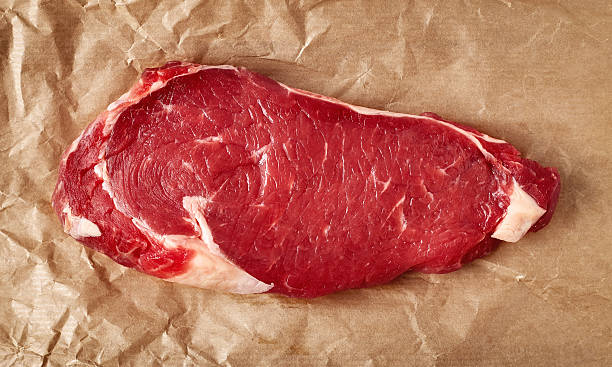 raw beef steak on recycling paper, from above - scotch steak imagens e fotografias de stock