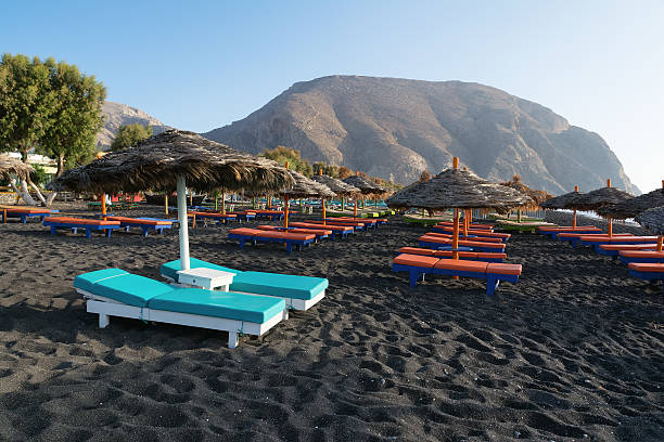 istock Tanning beds and umbrellas on Perissa beach, Santorini, Greece 612646894