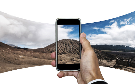 Businessman hand taking panorama photo of mountain landscape. isolated on white background