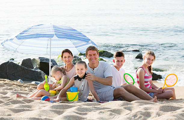 active family with  children together on beach sitting - family large american culture fun imagens e fotografias de stock