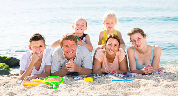 glad  family with four children lying on beach - family large american culture fun imagens e fotografias de stock