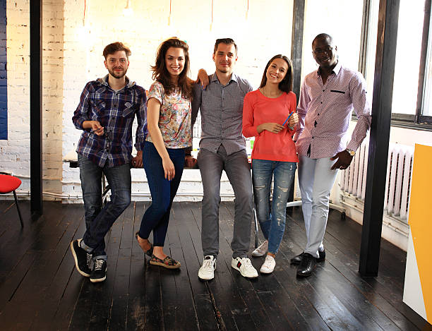 istock happy young people in meeting looking at camera and smiling. 612648726