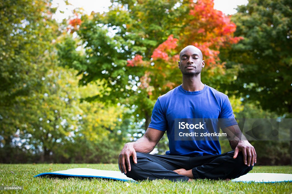 young man exercising yoga young black man wearing athletic wear sitting in the park exercising yoga Men Stock Photo