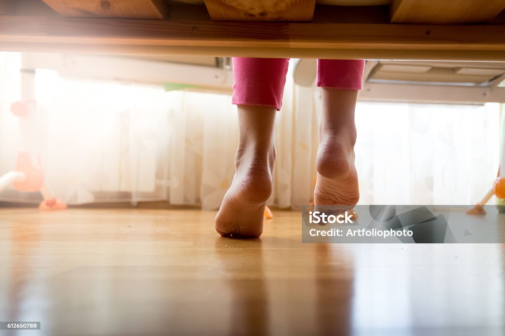 Image sous le lit sur une fille marchant sur le sol - Photo de Lit - Ameublement libre de droits