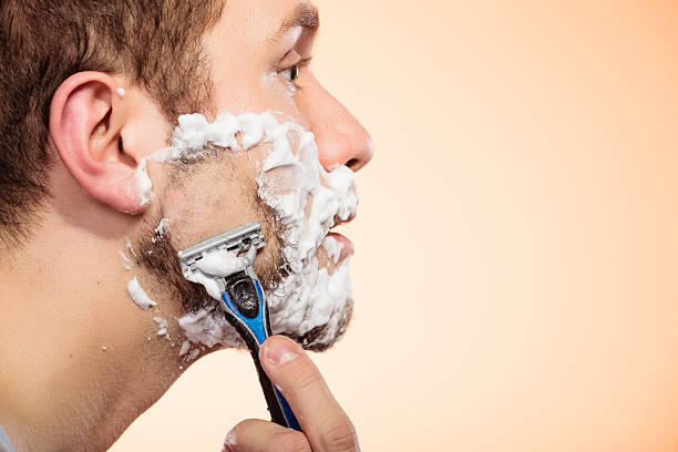 mann rasieren mit rasierer - rasieren stock-fotos und bilder