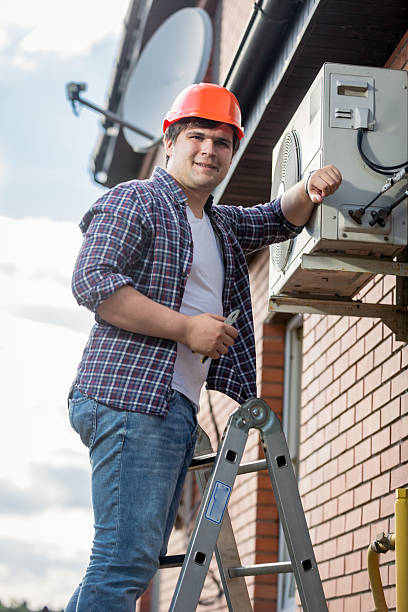 istock young repairman installing air conditioner on outer wall 612654020