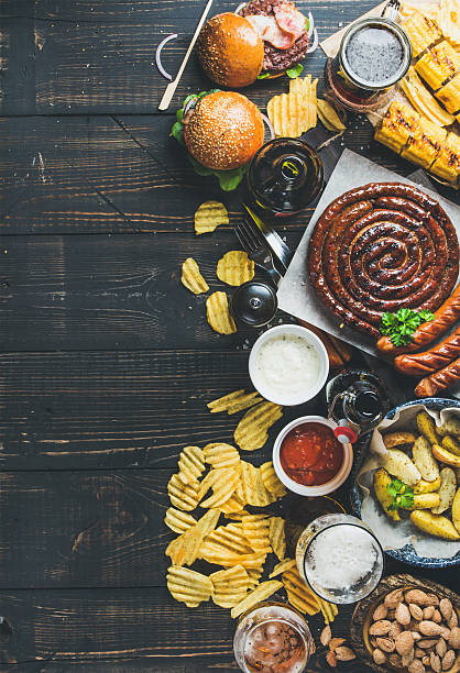 istock Octoberfest beer and snacks variety on dark scorched wooden background 612655920