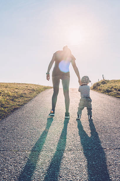 istock Baby walking with help of its parents - first steps 612658272