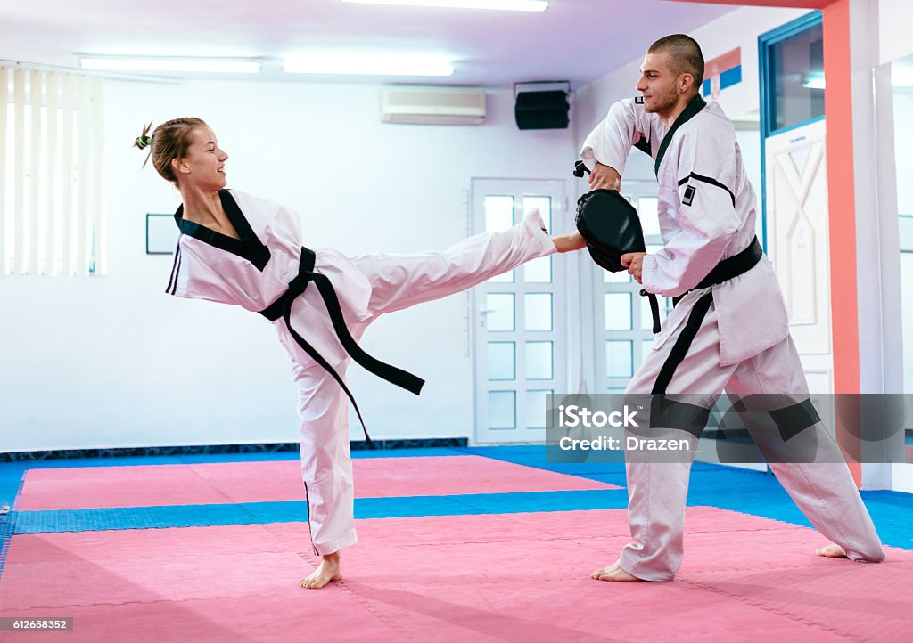 Young taekwondo girl with no upper limbs Focused sports woman with disability prepares for para-competition in taekwondo. Armless young adult, full of enthusiasm, exercising and working hard to achieve gold medal on upcoming global sport events in future.  20-24 Years Stock Photo
