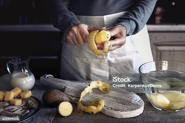 Peeling Potatoes On The Wooden Table Horizontal Stock Photo - Download Image Now - Raw Potato, Peeling Food, Peel - Plant Part