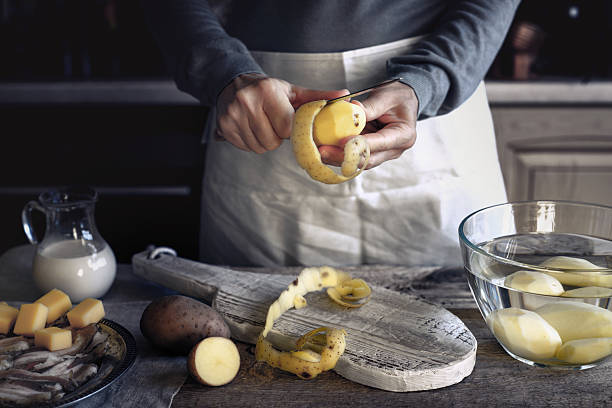 peeling potatoes on the wooden table horizontal - potato skin imagens e fotografias de stock