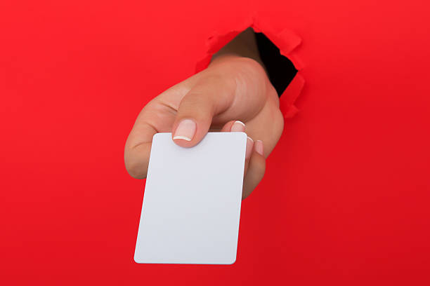 istock Female hand reaching through torn red paper sheet 612659652