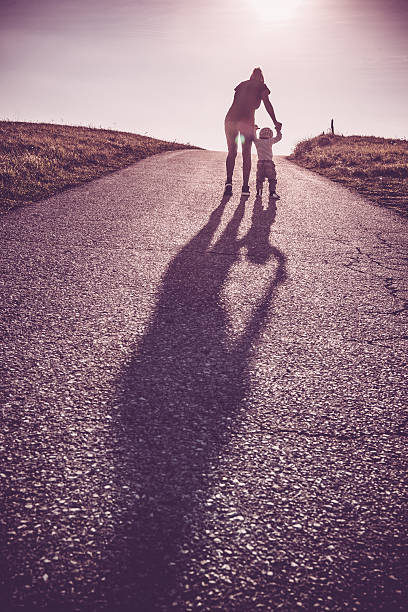 istock Baby walking with help of its parents - first steps 612659746