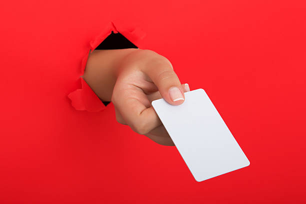 istock Female hand reaching through torn red paper sheet 612659868