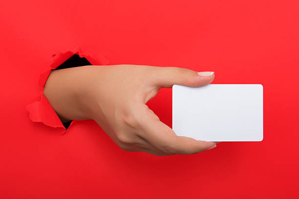 istock Female hand reaching through torn red paper sheet 612660106