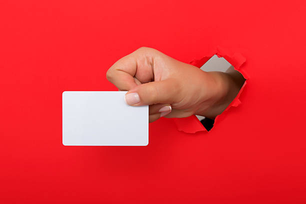 istock Female hand reaching through torn red paper sheet 612660512