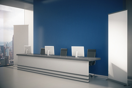 Side view of blue interior with New York city view, blank posters, empty wall and reception desk with computer monitors. Mock up, 3D Rendering