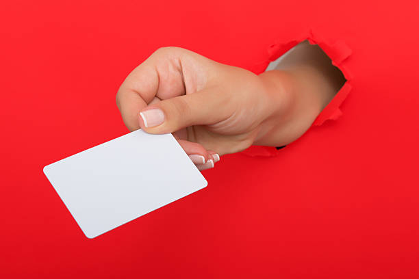 istock Female hand reaching through torn red paper sheet 612660752