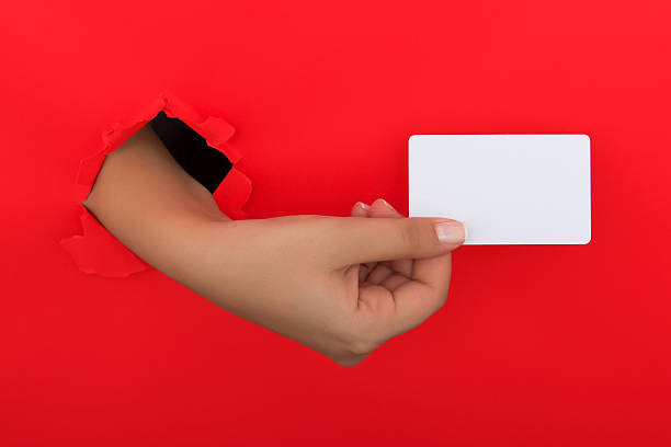 istock Female hand reaching through torn red paper sheet 612660984