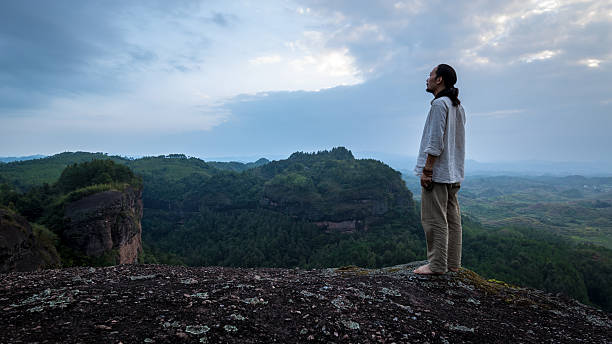 istock Chinese man, standing on a stone mountain 612661402
