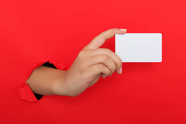 istock Female hand reaching through torn red paper sheet 612661408