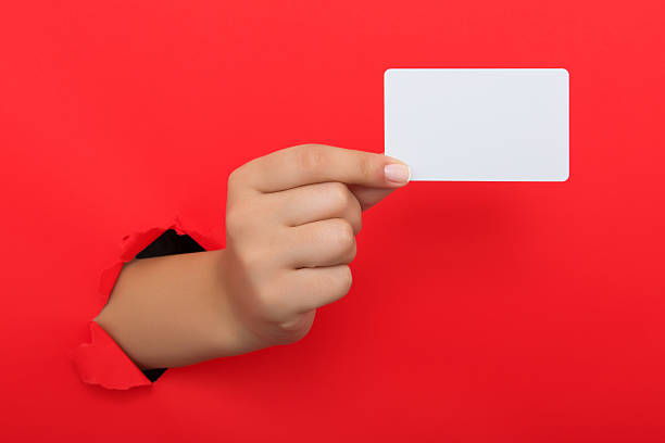 istock Female hand reaching through torn red paper sheet 612661570