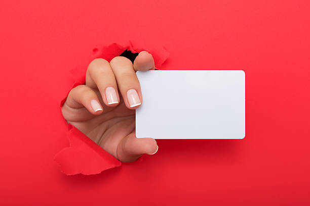istock Female hand reaching through torn red paper sheet 612713762