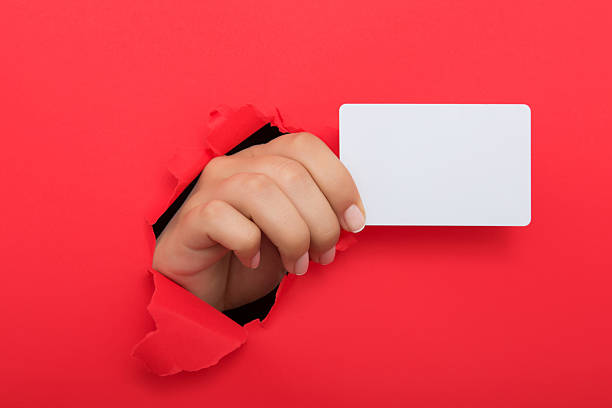 istock Female hand reaching through torn red paper sheet 612713992