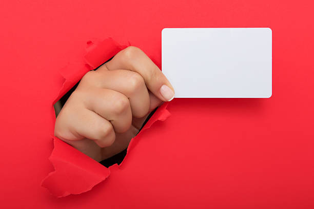 istock Female hand reaching through torn red paper sheet 612714174