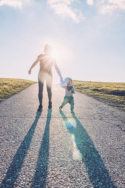 istock Baby walking with help of its parents - first steps 612714504