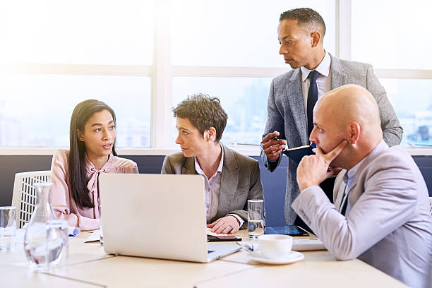 istock Mature businessman supervising his employees as they work 612715164