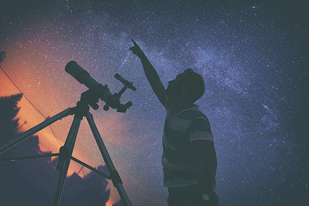istock Man looking at the stars with telescope beside him. 612717630