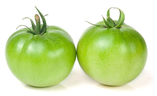 istock Two green unripe tomato isolated on white background 612719448