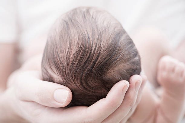 Newborn baby in adult hands