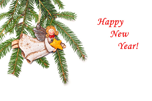 New Year's congratulatory background with fir branches and a ceramic angel.