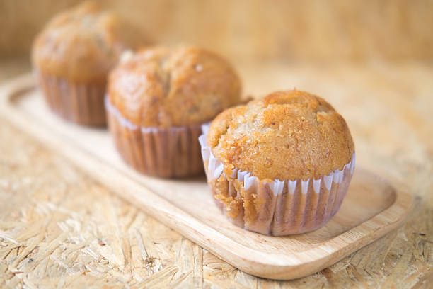 istock Fresh baked muffins from oven on wood tray 612720424