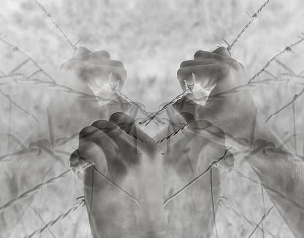 istock Artistic surreal tortured hands grasping desperately barbed wire (infrared) 612722188
