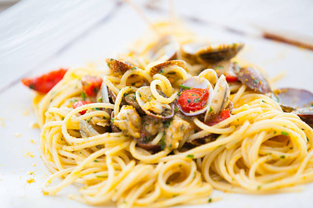 Spaghetti with clams, bottarga and fresh tomatoes stock photo