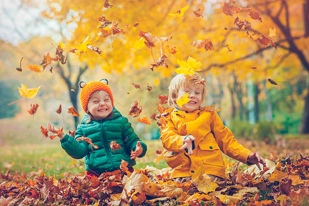 little boy and girl in autumn park - smiling little girls little boys autumn imagens e fotografias de stock